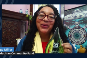 Margo Miller, Environmental Health Hero winner holds up award plaque in video screenshot 