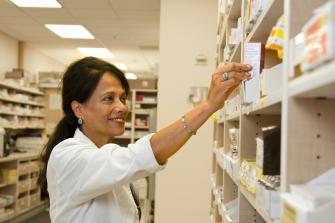 Pharmacist selecting a medicine from the pharmacy inventory